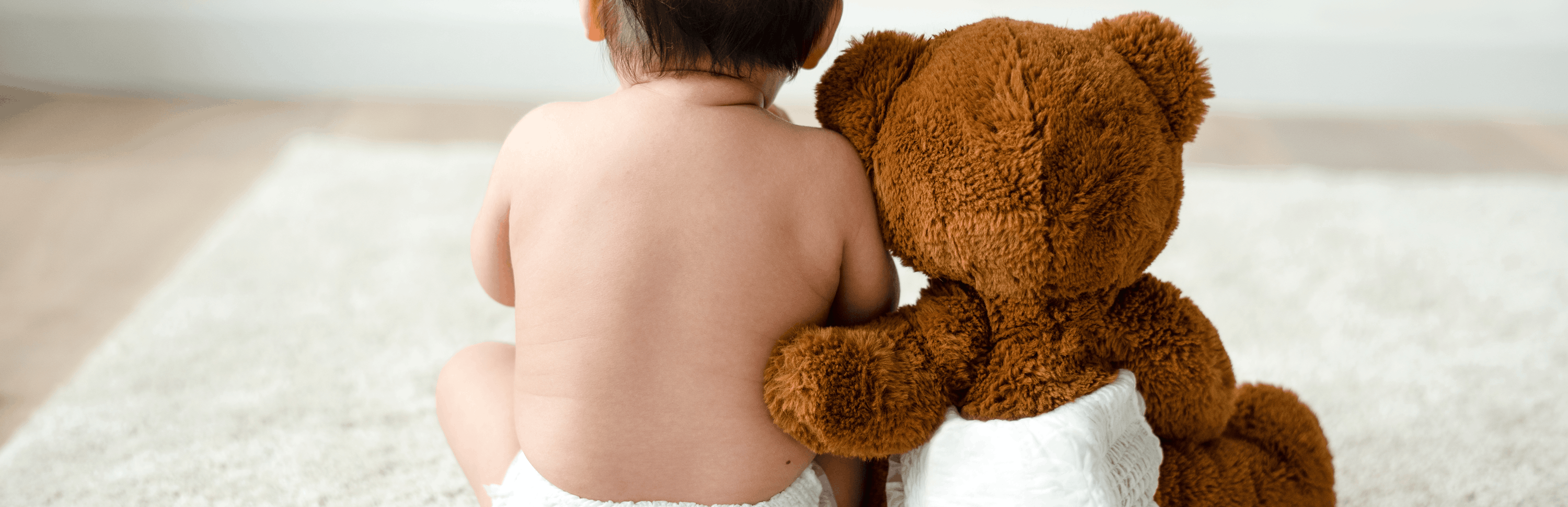 Gyerek és kismaci Plüssmaci átöleli a babát